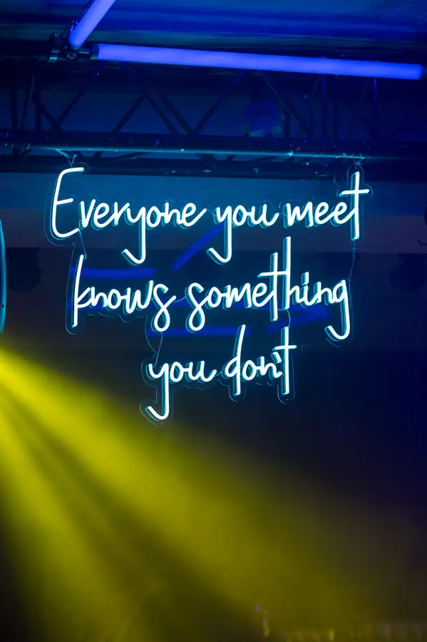 Neon typographic sign glowing at an 80s-themed party