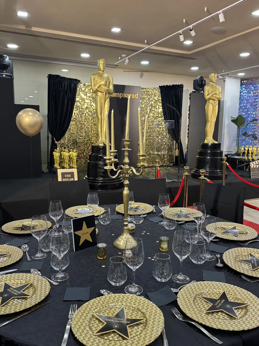 Illuminated gold scallop wall with dessert stations at the Igan gala