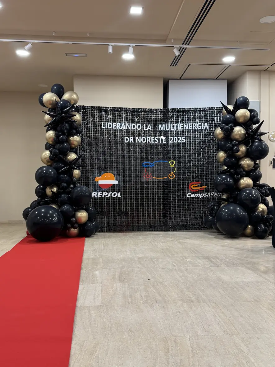 Branded photocall arch with black and gold balloons on a red carpet