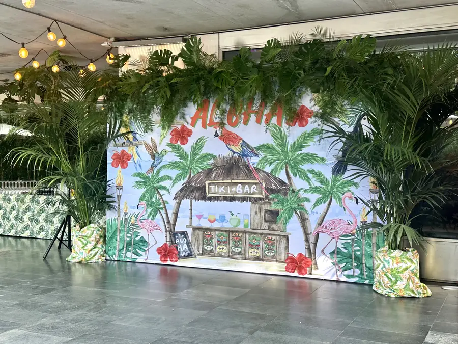 ‘Aloha’ painted tropical backdrop behind a terrace lounge