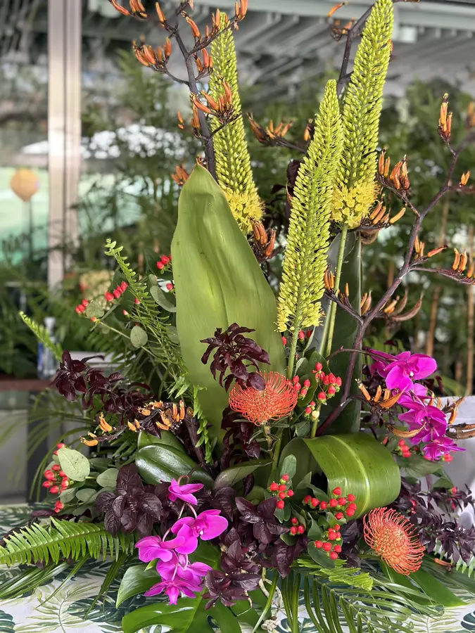 Vivid tropical floral arrangement with orchids and heliconia