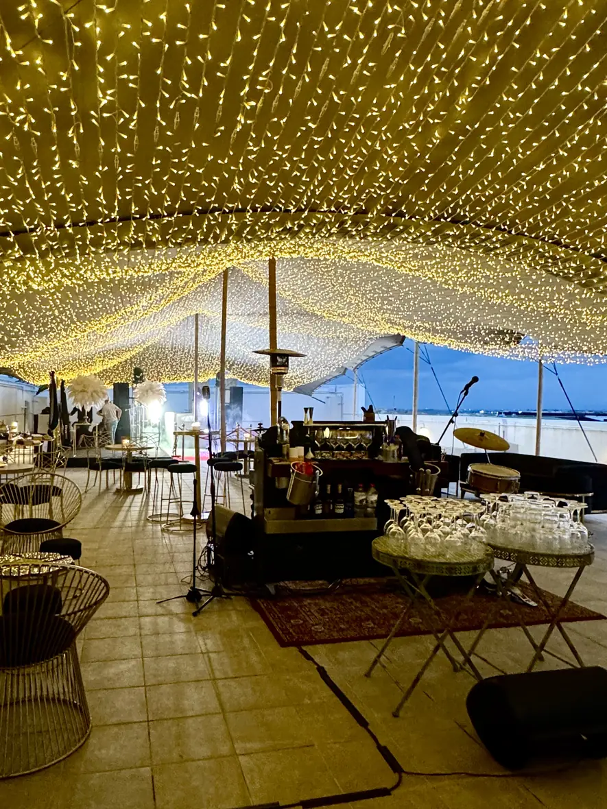 Fairy-light canopy glowing above gala dinner tables
