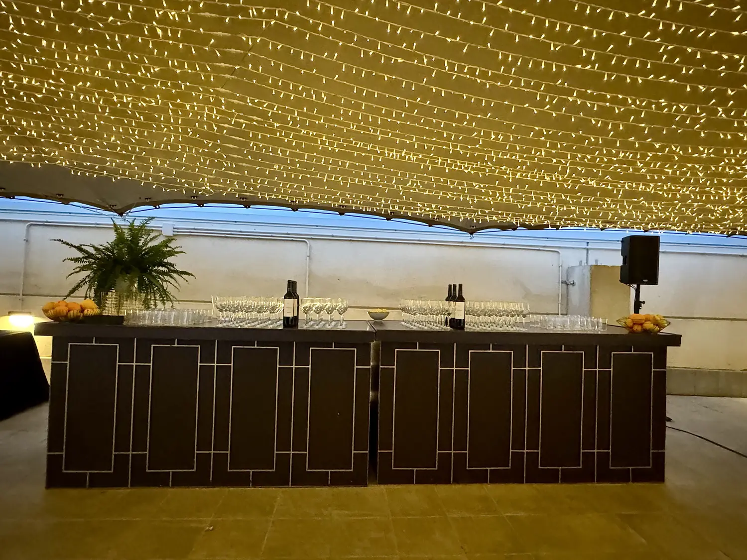 A canopy of thousands of warm fairy lights glowing above a gala dinner