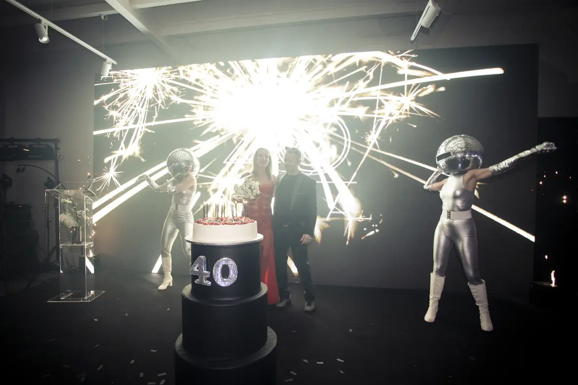 Sparkler-lit birthday cake at a nightclub-style private celebration