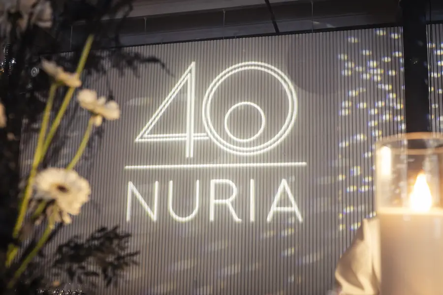 Neon numerals and gold branding wall at a private 40th birthday