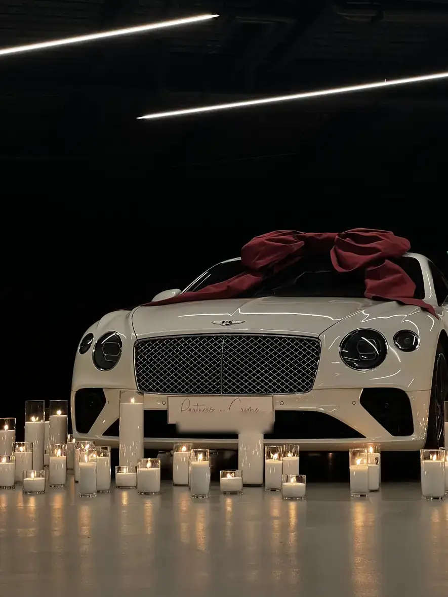 White Bentley amid a sea of white candles, seen from the side
