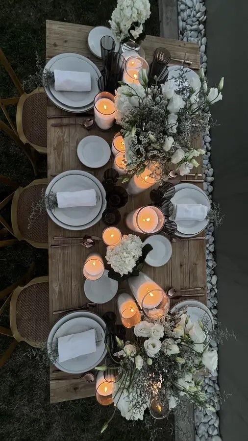 Overhead view of a tablescape with white florals and candles on a wood table